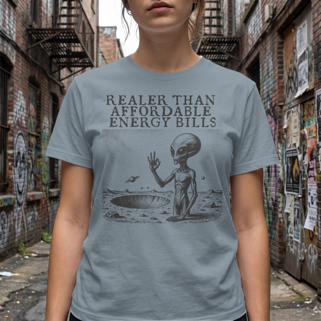 Grey t-shirt with alien in crater and text "Realer Than Affordable Energy Bills".