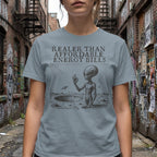 Grey t-shirt with alien in crater and text "Realer Than Affordable Energy Bills".