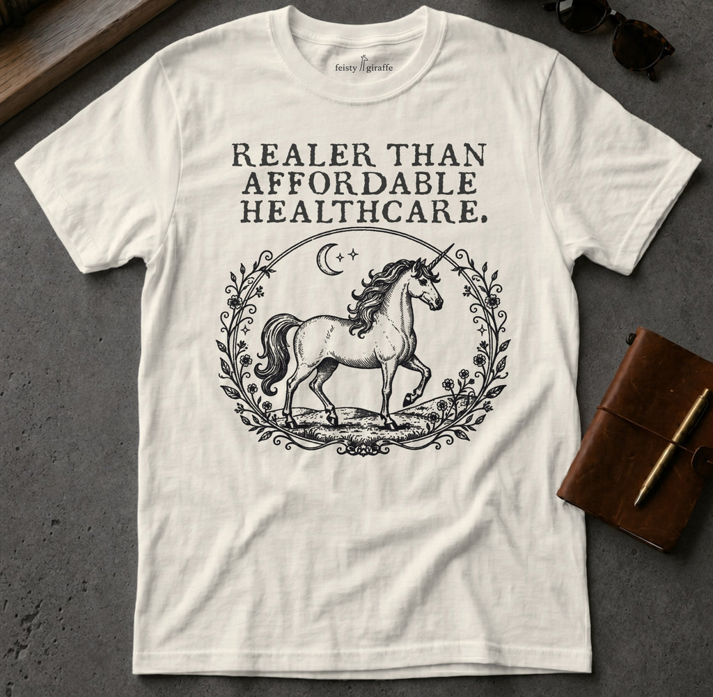 White t-shirt with a unicorn and "Realer Than Affordable Healthcare" text.