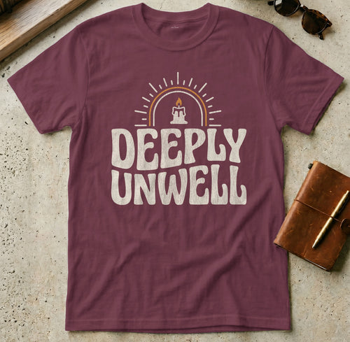 Maroon t-shirt with "DEEPLY UNWELL" text and a candle graphic.