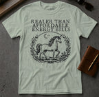 Unicorn graphic with "Realer than affordable energy bills" text on a light green t-shirt.