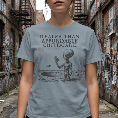 Gray t-shirt with alien graphic and text "REALER THAN AFFORDABLE CHILDCARE."