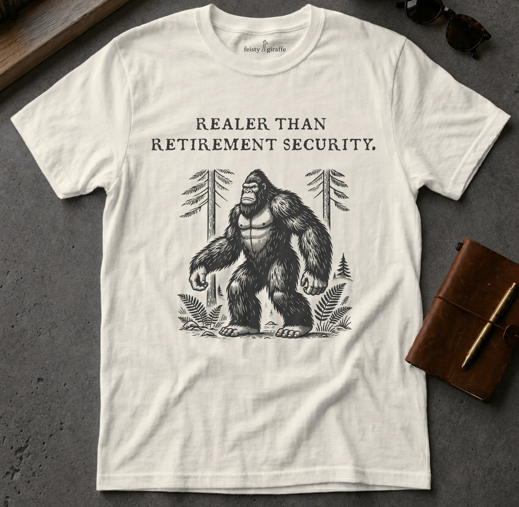 White t-shirt with Bigfoot illustration and "Realer Than Retirement Security" text.