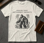 White t-shirt with Bigfoot illustration and "Realer Than Retirement Security" text.