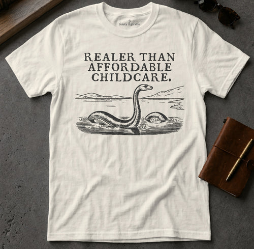 White t-shirt with "Realer Than Affordable Childcare" and Loch Ness Monster graphic.