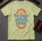 "Former gifted child" text on a pale yellow t-shirt with rainbow graphic.