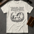 White t-shirt with a unicorn and text that reads "Realer than affordable energy bills."