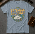 Light blue t-shirt with "Expecting the Worst" text and smiling cloud graphic.