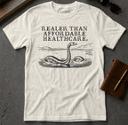 White t-shirt with "Real Clear Than Affordable Healthcare" text and Loch Ness Monster illustration.