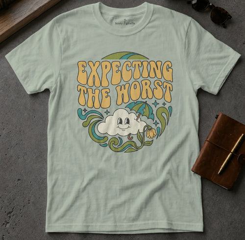 Light blue t-shirt with "Expecting the worst" text and smiling cloud graphic.