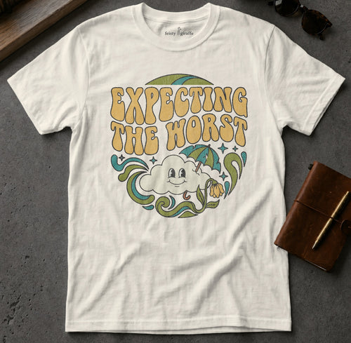 White t-shirt with retro "EXPECTING THE WORST" graphic featuring a cloud and umbrella.